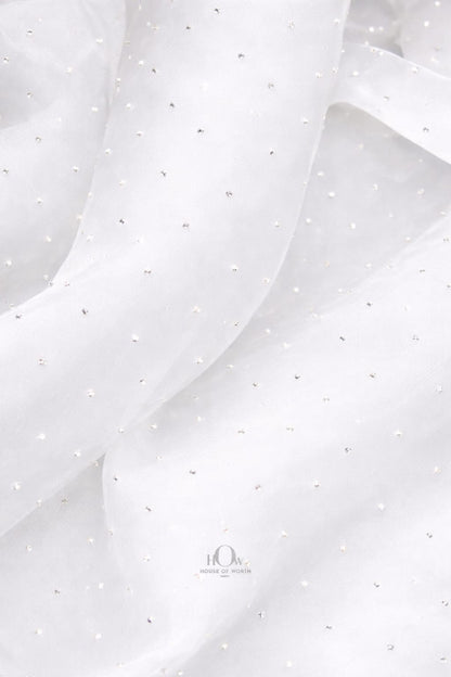 White organza material with glittering crystal embellishments
