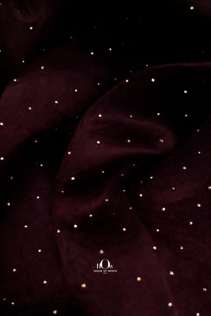 Close-up of dark wine organza material with glittering crystal embellishments