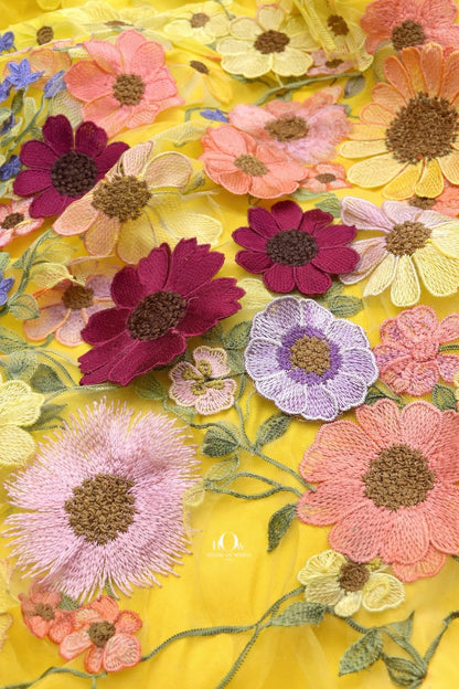 Yellow floral applique fabric detailing showing dimensional embroidery, ideal for boutique designer wear